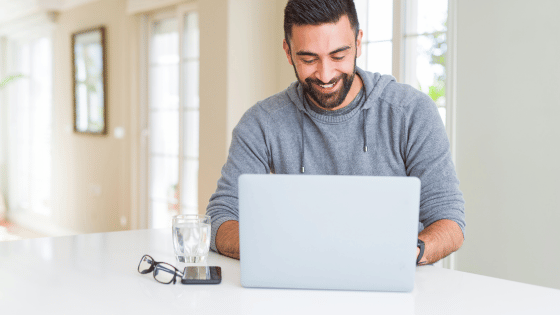 Man smiling working using a Windows 11 Professional computer laptop